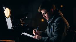 Journalist writing a story in a cozy café setting.